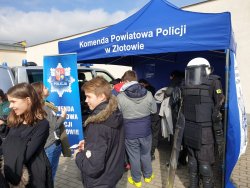 Policyjne stoisko na dniach otwartych CKZiU w Złotowie. W tle widać umundurowanie policjanta Oddziałów Prewencji Policji