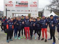 Reprezentacja Komendanta Głównego Policji wspólne zdjęcie na tle mety maratonu w Warszawie