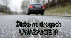 Zdjęcie przedstawia samochód stojący na drodze i napis uważajcie na drogach ślisko