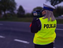 Na zdjęciu policjantka Wydziału Ruchu Drogowego z radarem do mierzenia prędkości.