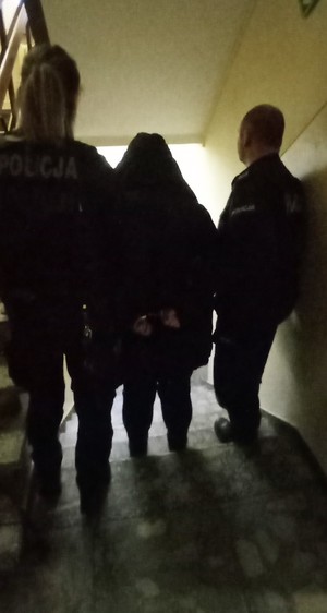 Para policjantów prowadzi zatrzymaną kobietę