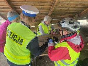 Policjantka przekazuje kamizelki odblaskowe